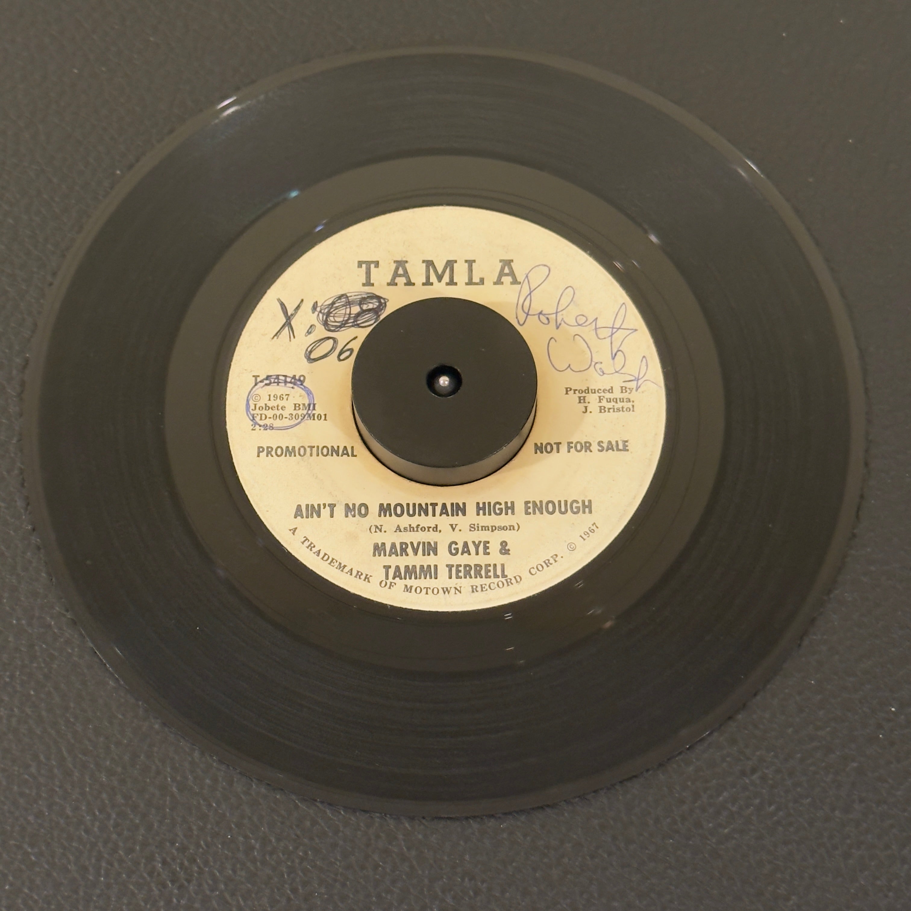 7" vinyl record by Marvin Gaye & Tammi Terrell featuring "Ain't No Mountain High Enough", released on Tamla (T-54149), in G+ (Good Plus) condition, classic analog collectable for turntable playback. Super Rare Promotional Copy!!!!!  Writing on both sides of label & a sticker on one side. Plays great.