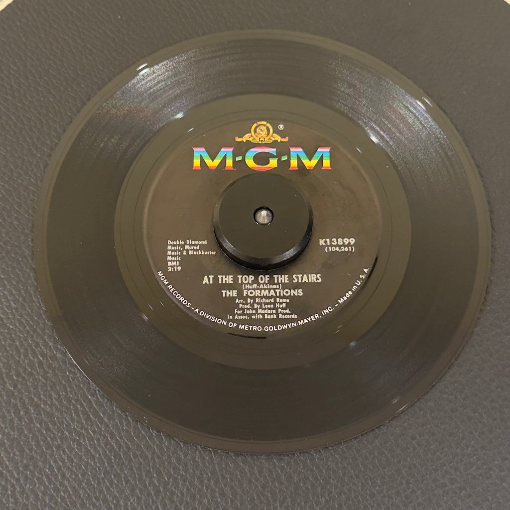 7" vinyl record by Formations, The featuring "At The Top Of The Stairs/Magic Melody", released on MGM Records (K13899), in VG (Very Good) condition, classic analog collectable for turntable playback. Philly Soul masterpiece and an immortal Northern Soul dancefloor burner.