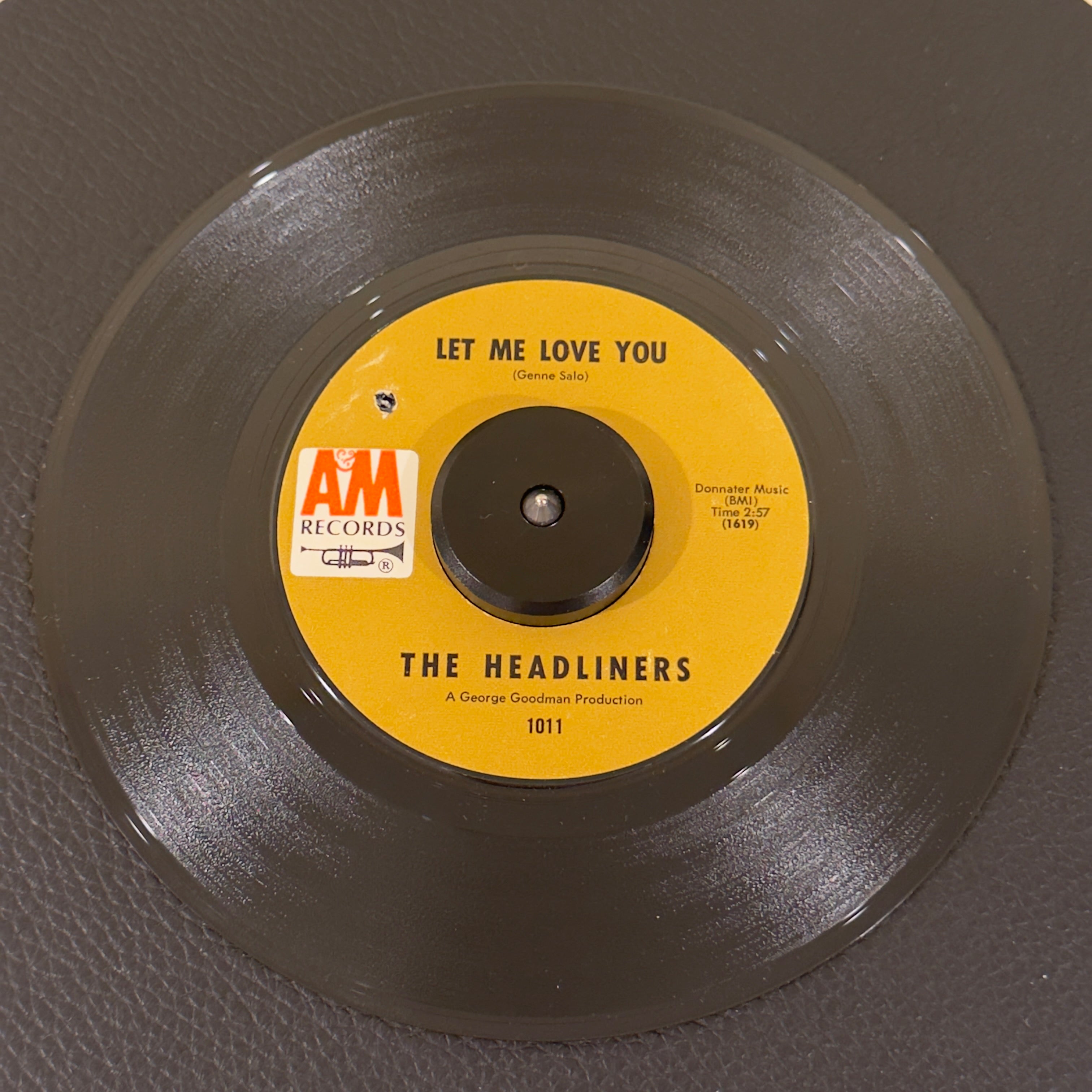 7" vinyl record by Headliners, The featuring "Let Me Love You/I'm So Tired", released on A&M Records (1011), in NM (Near Mint) condition, classic analog collectable for turntable playback. 1969 Reissue in original A&M sleeve.