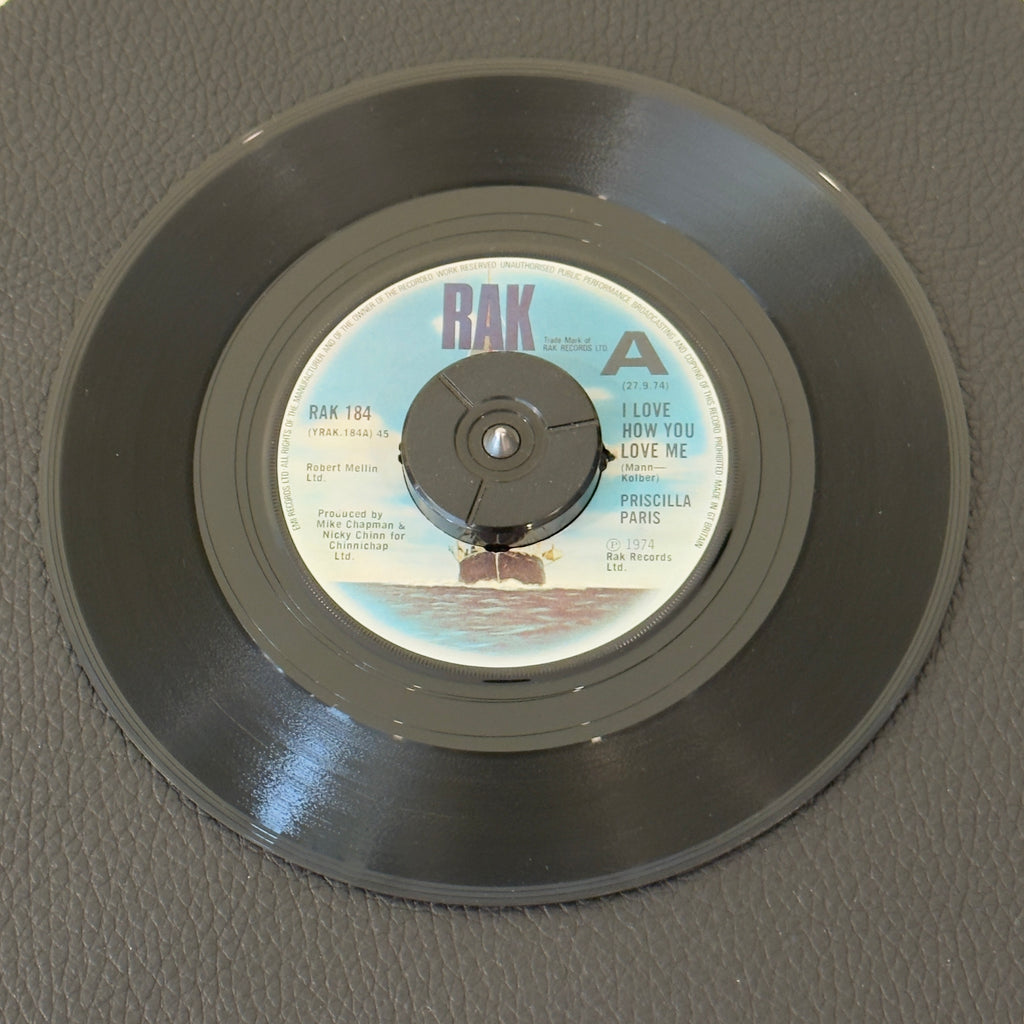 7" vinyl record by Priscilla Paris featuring "I Love How You Love Me/Over You", released on RAK (RAK 184), in VG+ (Very Good Plus) condition, classic analog collectable for turntable playback. Promo Copy - UK Pressing. Center removed - 45 adapter needed to play.