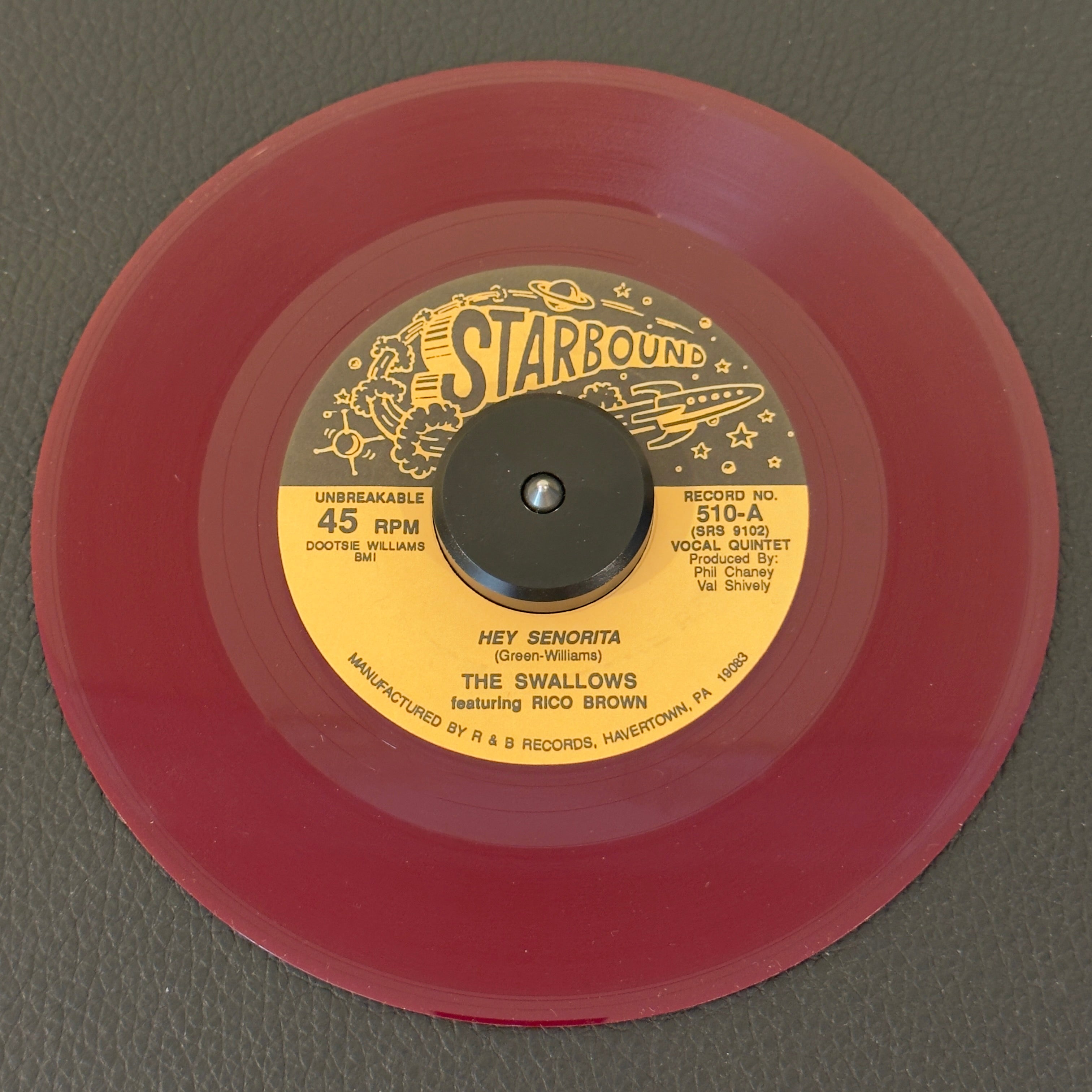 7" vinyl record by Swallows, The featuring "Hey Senorita/My Grandmother's Christmas", released on Starbound (510), in NM (Near Mint) condition, classic analog collectable for turntable playback. Pressed on gorgeous dark maroon translucent wax.