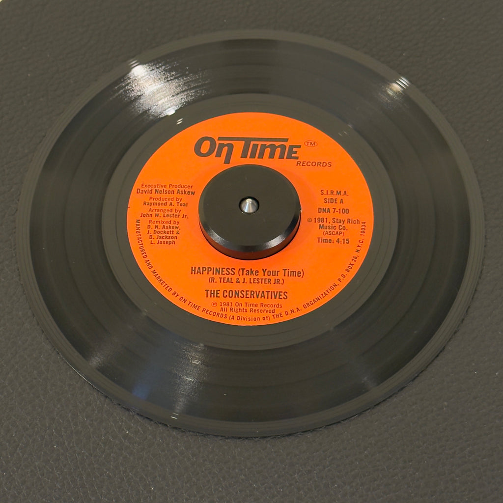 7" vinyl record by Conservatives, The featuring "Happiness (Take Your Time)/Theme From Happiness", released on On Time Records (DNA 7-100), in NM (Near Mint) condition, classic analog collectable for turntable playback. Pristine copy of a highly elusive piece of early '80s independent NYC soul.