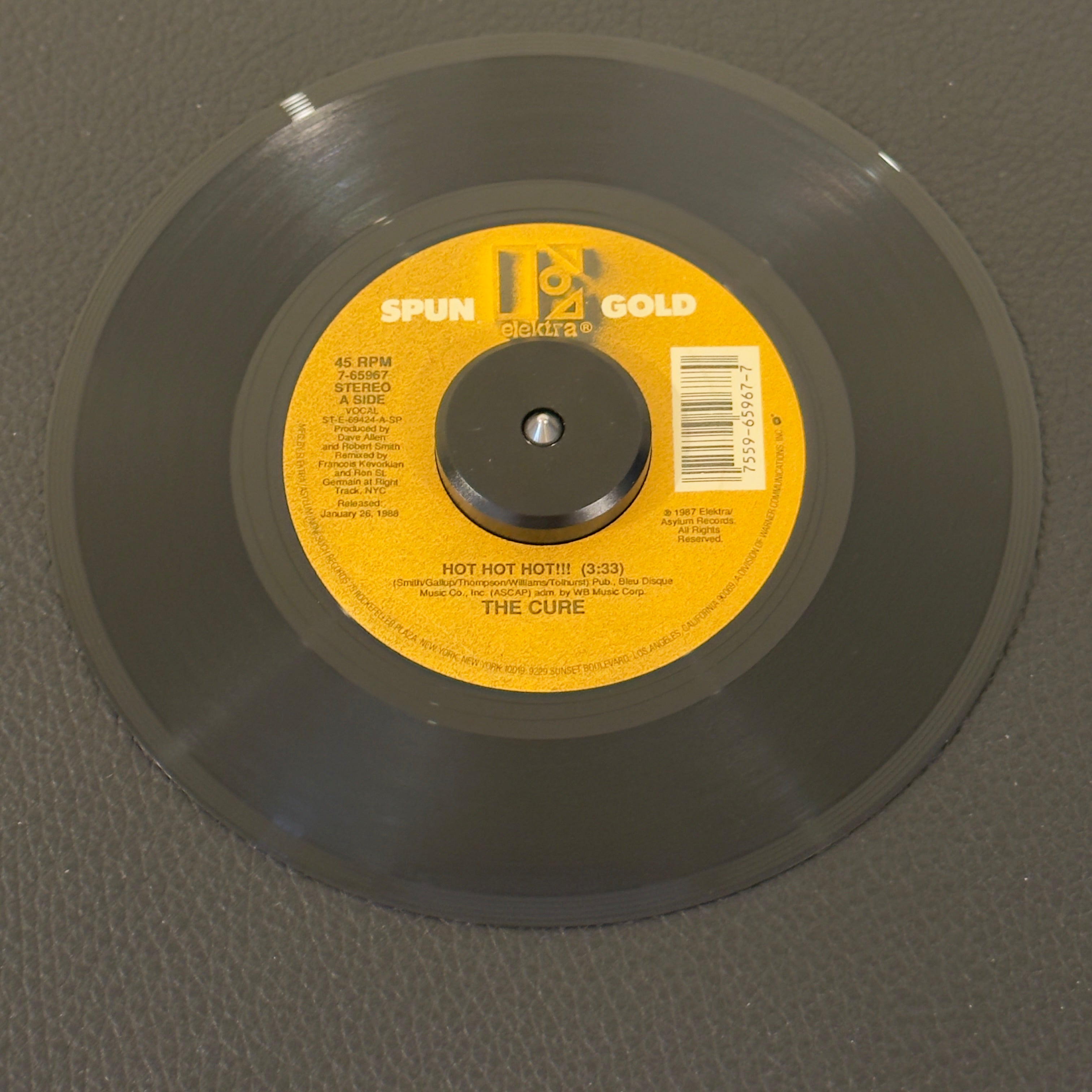 7" vinyl record by Cure, The featuring "Hot Hot Hot!!! (Remix)/Why Can't I Be You?", released on Elektra Spun Gold (7-65967), in VG+ (Very Good Plus) condition, classic analog collectable for turntable playback. Two back-to-back mega-hits from The Cure’s multi-platinum masterpiece Kiss Me, Kiss Me, Kiss Me. Spun Gold Series.