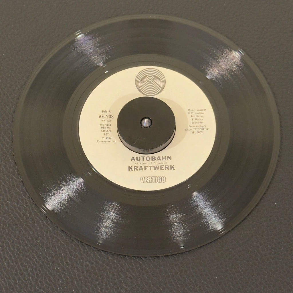 7" vinyl record by Kraftwerk featuring "Autobahn/Morgenspaziergang = Morning Walk", released on Vertigo (VE-203), in VG+ (Very Good Plus) condition, classic analog collectable for turntable playback. US pressing of the historic single that helped bring electronic music into the pop mainstream. Kraftwerk’s very first track to integrate sung vocals alongside their modular synthesizers.
