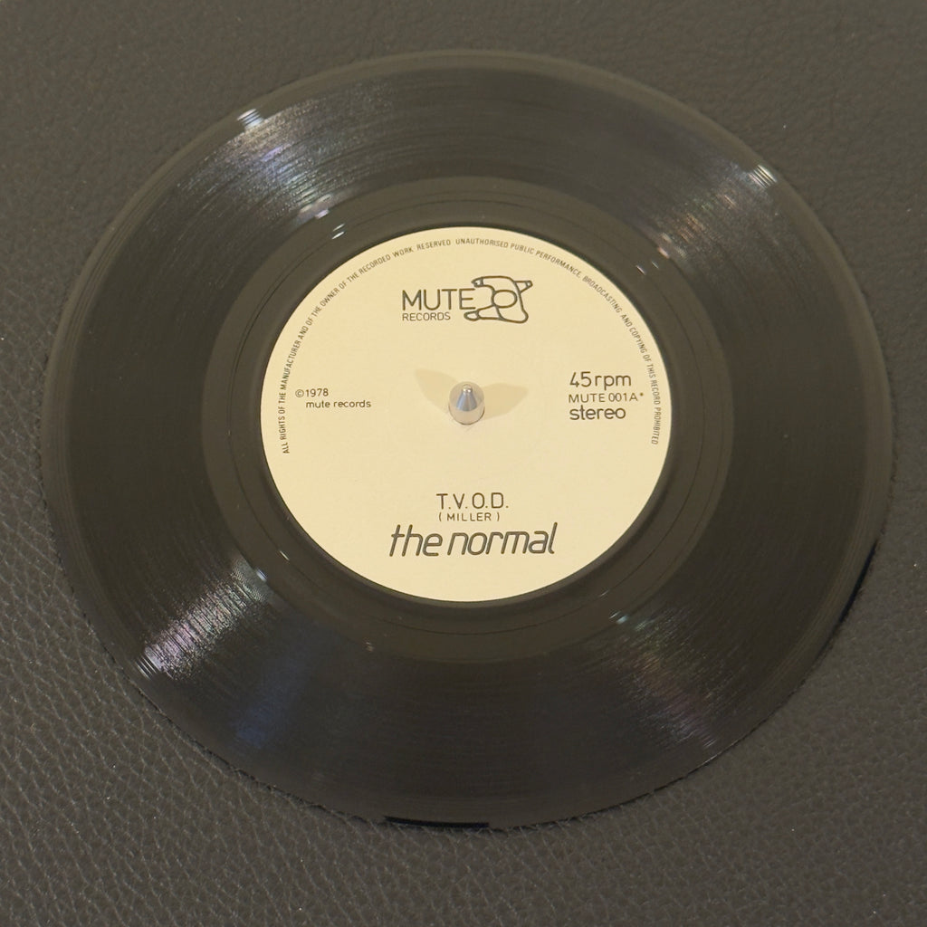7" vinyl record by Normal, The featuring "T.V.O.D./Warm Leatherette", released on Mute (Mute001), in VG+ (Very Good Plus) condition, classic analog collectable for turntable playback. Exceptional vintage repress copy of the monumental single that single-handedly birthed industrial synth-pop and launched the historic Mute Records empire.