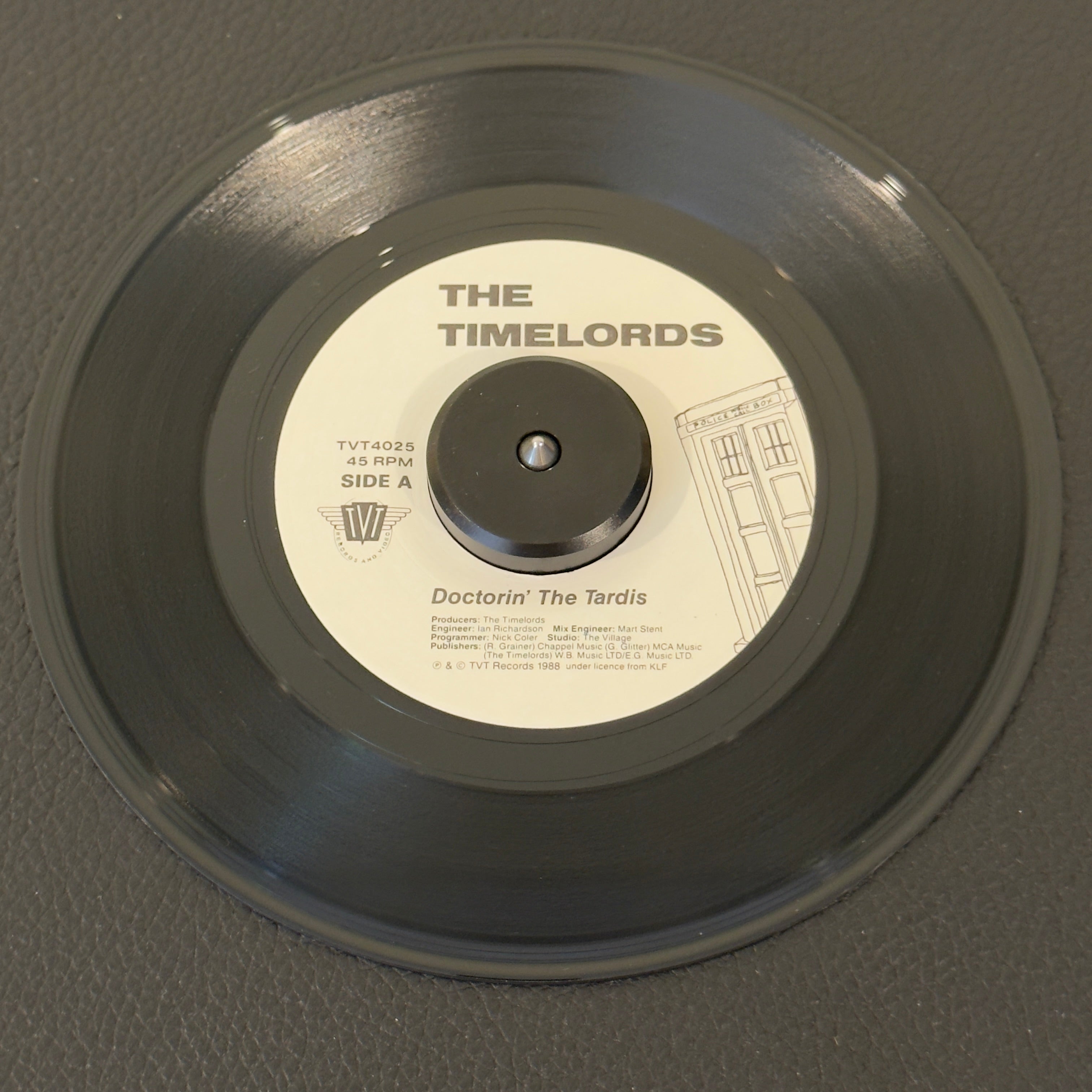 7" vinyl record by Timelords, The featuring "Doctorin' The Tardis/Gary In The Tardis (Doctorin' The Tardis – Remix)", released on TVT Records (TVT 4025), in NM (Near Mint) condition, classic analog collectable for turntable playback. 1988 house music collector's gem pressed on high-quality translucent black compound.