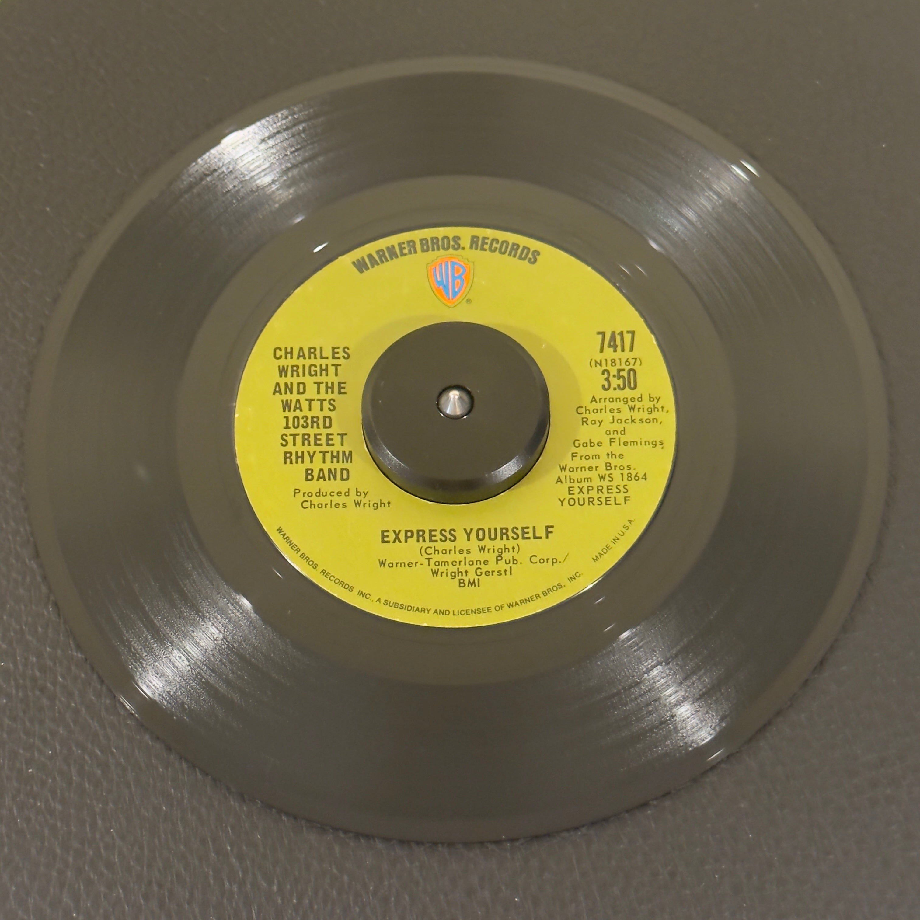 7" vinyl record by Charles Wright And The Watts 103rd Street Rhythm Band featuring "Express Yourself/Living On Borrowed Time", released on Warner Bros. Records (7417), in VG+ (Very Good Plus) condition, classic analog collectable for turntable playback. 1970 single featuring the timeless funk anthem which famously served as the foundation for N.W.A's iconic hip-hop track of the same name.