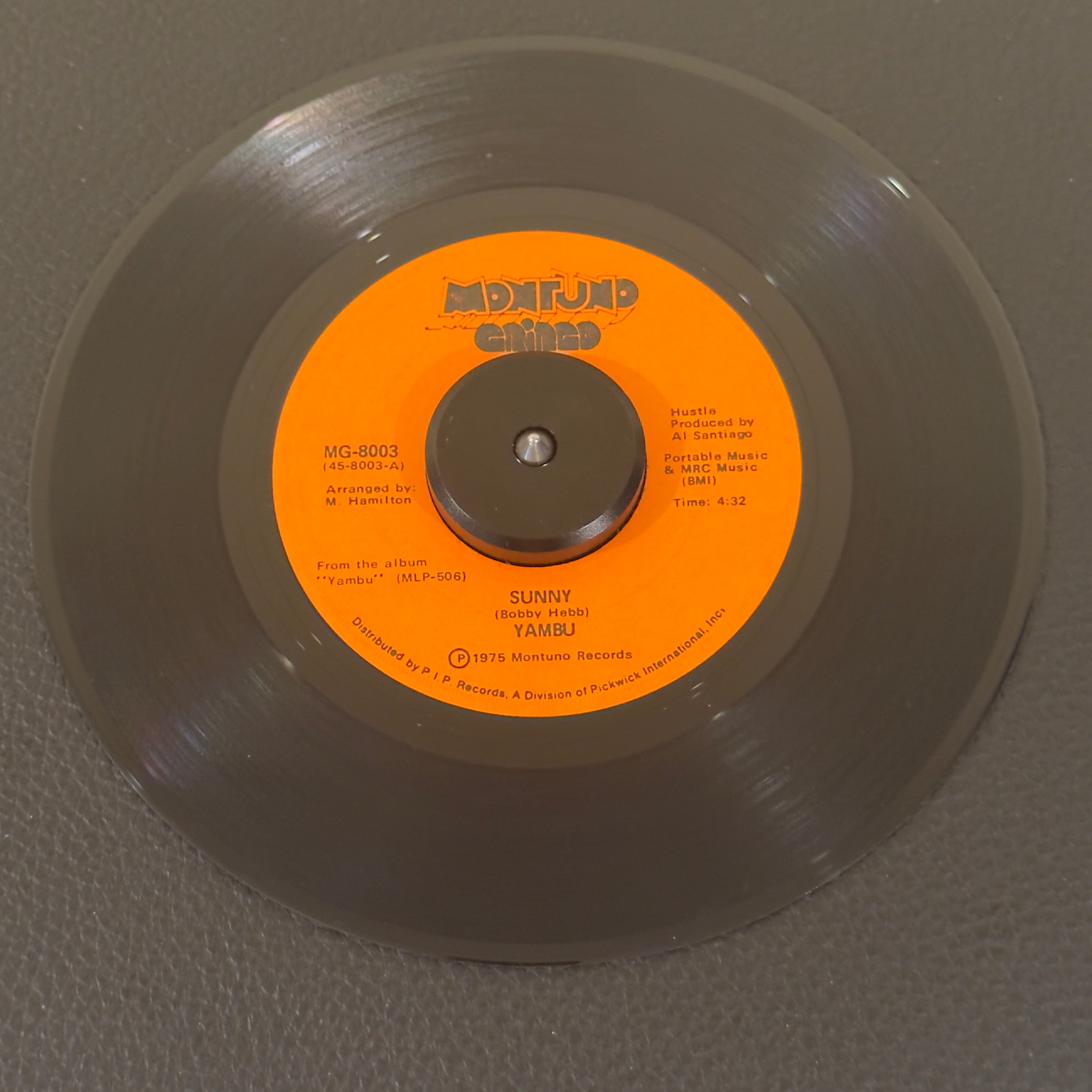 7" vinyl record by Yambu featuring "Sunny/Caballo", released on Montuno Gringo (MG-8003), in NM (Near Mint) condition, classic analog collectable for turntable playback. 1975 single is a holy grail cornerstone for Latin funk DJs, rare groove collectors, and club selectors worldwide.  Highly desirable US original pressing manufactured at Goldisc Recording Products.
