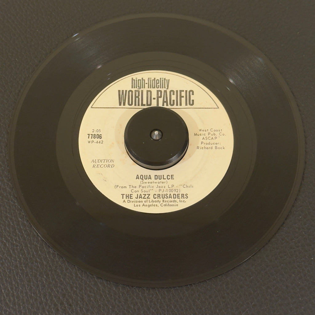 7" vinyl record by Jazz Crusaders, The featuring "Aqua Dulce/Soul Bourgeoisie", released on World Pacific Records (77806), in VG+ (Very Good Plus) condition, classic analog collectable for turntable playback. Original 1966 World Pacific Records Promotional Copy of a beautifully preserved artifact of 1960s soul-jazz history.