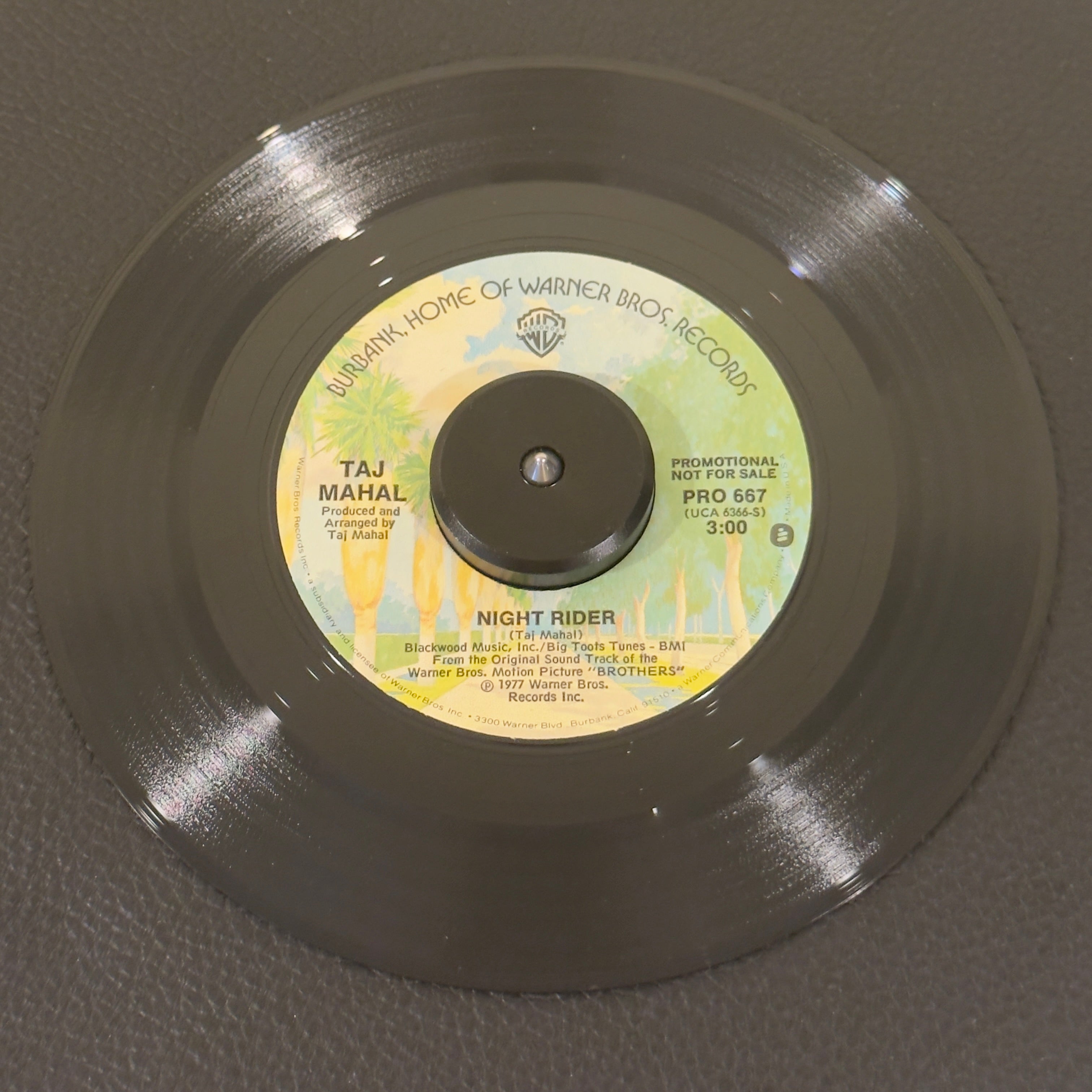 7" vinyl record by Taj Mahal featuring "Night Rider/Love Theme in the key of D", released on Warner Bros. Records (PRO 667), in VG+ (Very Good Plus) condition, classic analog collectable for turntable playback. An essential crossover piece for deep funk DJs, cinematic soundtrack collectors, and Taj Mahal completists.  Original WB sleeve included.