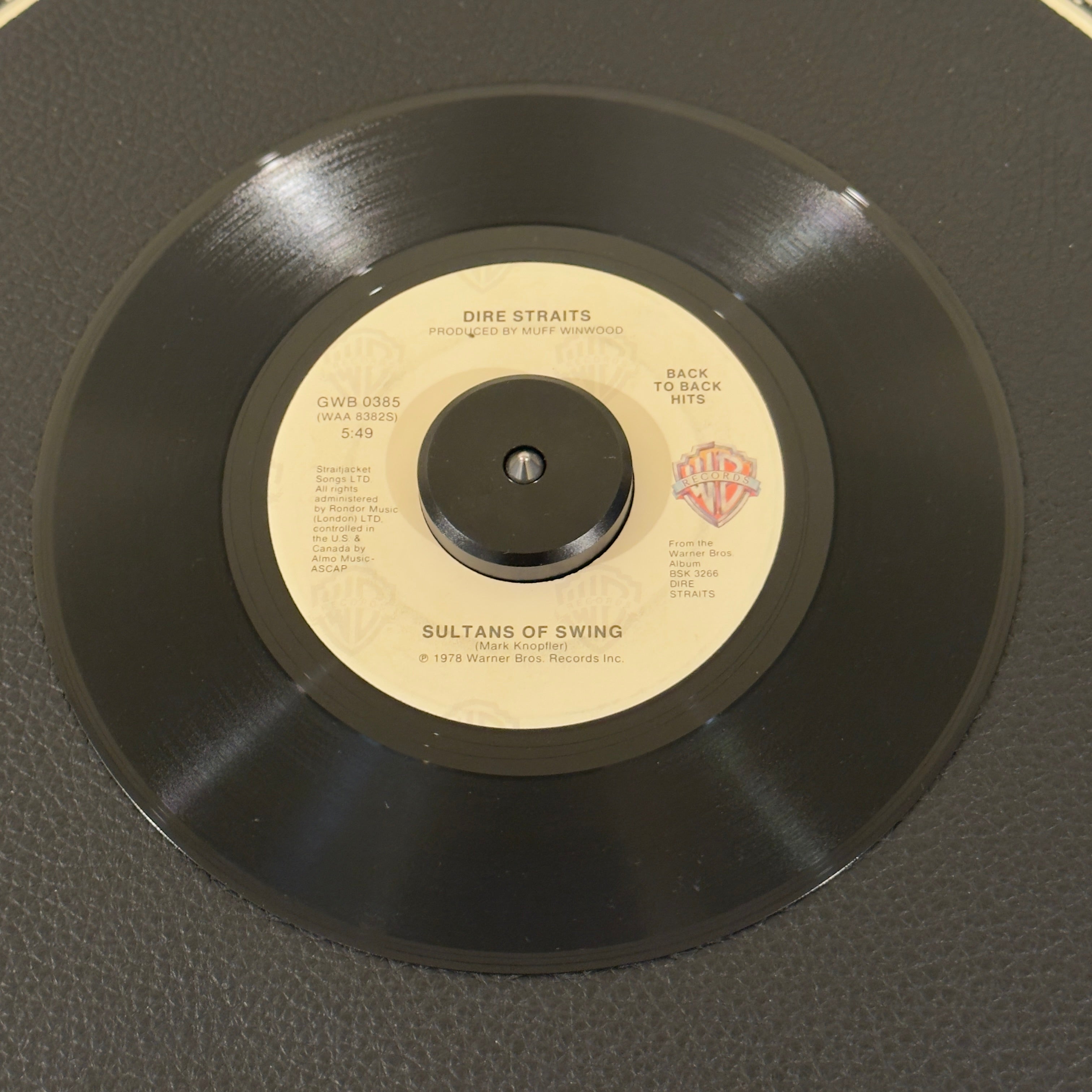 7" vinyl record by Dire Straits featuring "Sultans Of Swing/Down To The Waterline", released on Warner Bros. Records (GWB 0385), in VG+ (Very Good Plus) condition, classic analog collectable for turntable playback. This dual-hit reissue packs two of the finest tracks from the bands landmark 1978 debut onto a single jukebox-ready 45.  Original sleeve included.