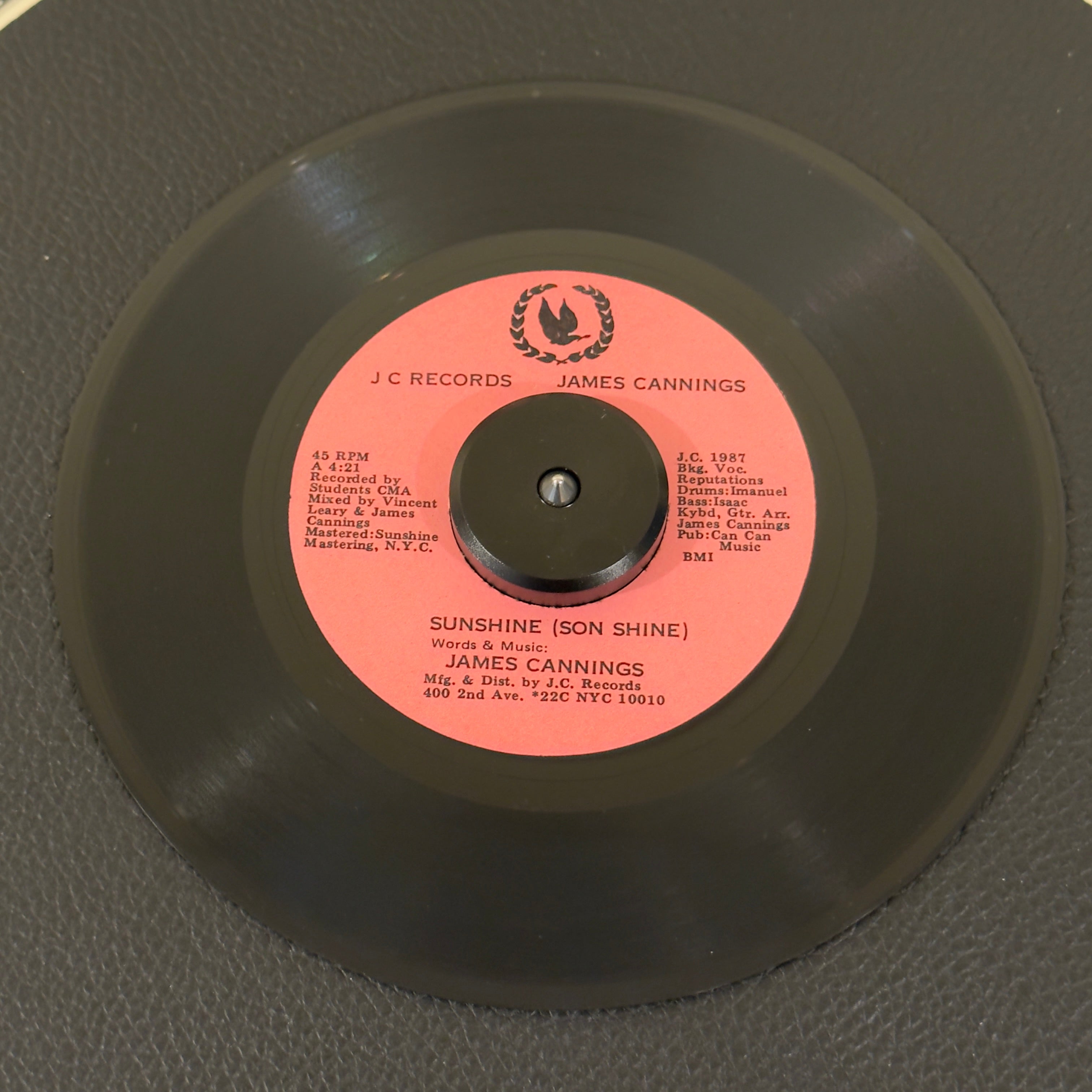 7" vinyl record by James Cannings featuring "Sunshine/As Time Goes By We Remember Ourselves", released on JC Records (), in VG (Very Good) condition, classic analog collectable for turntable playback. Highly sought-after vinyl for deep roots-reggae collectors and private-press obscurity hunters that features synthesizers by the legendary Tyrone Downie (Bob Marley & The Wailers).