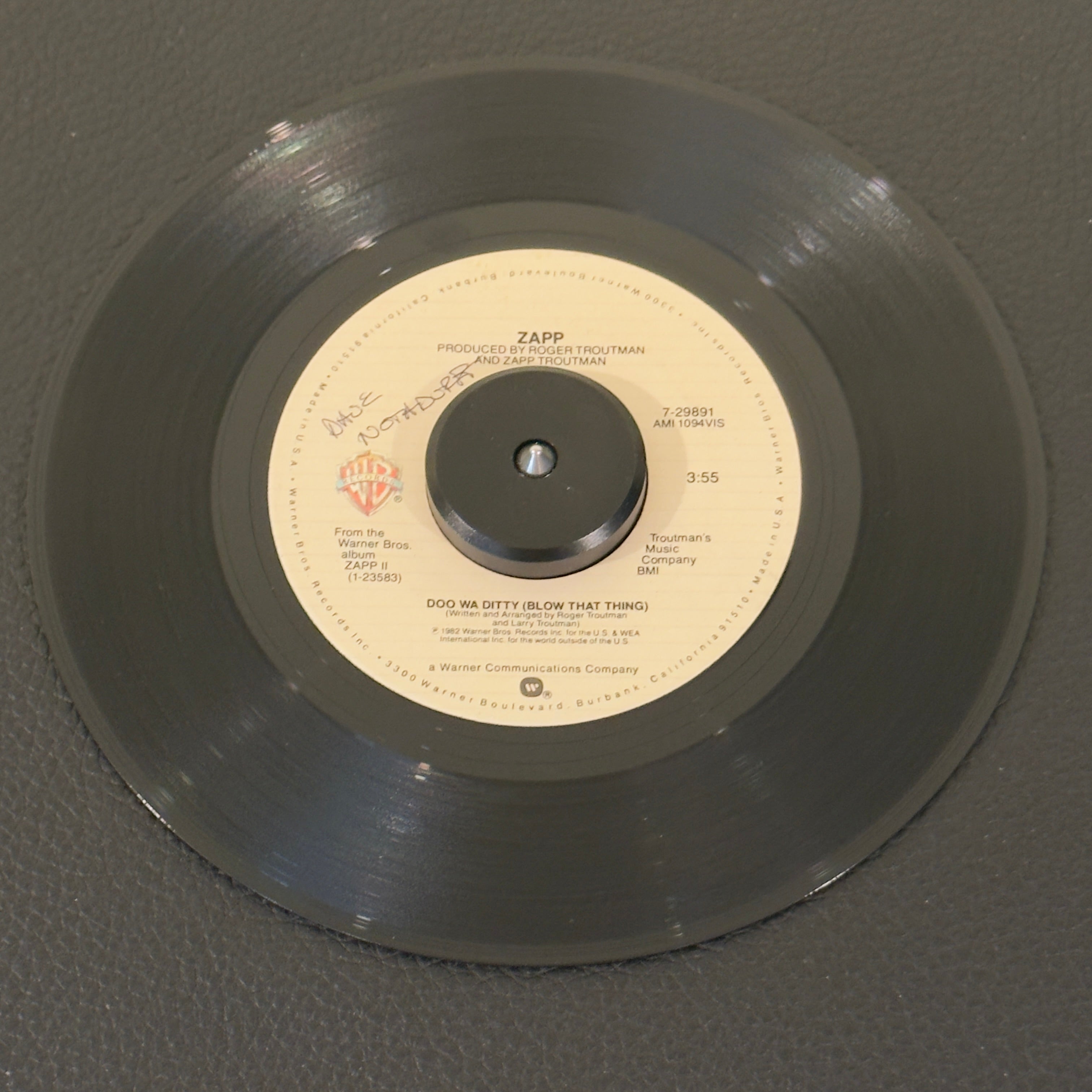 7" vinyl record by Zapp featuring "Doo Wa Ditty (Blow That Thing)/Come On", released on Warner Bros. Records (7-29891), in VG+ (Very Good Plus) condition, classic analog collectable for turntable playback. 1982 electro-funk featuring heavy synthesized basslines, crisp electronic handclaps, and the iconic, pioneering talk-box vocal production that shaped G-Funk and West Coast hip-hop.