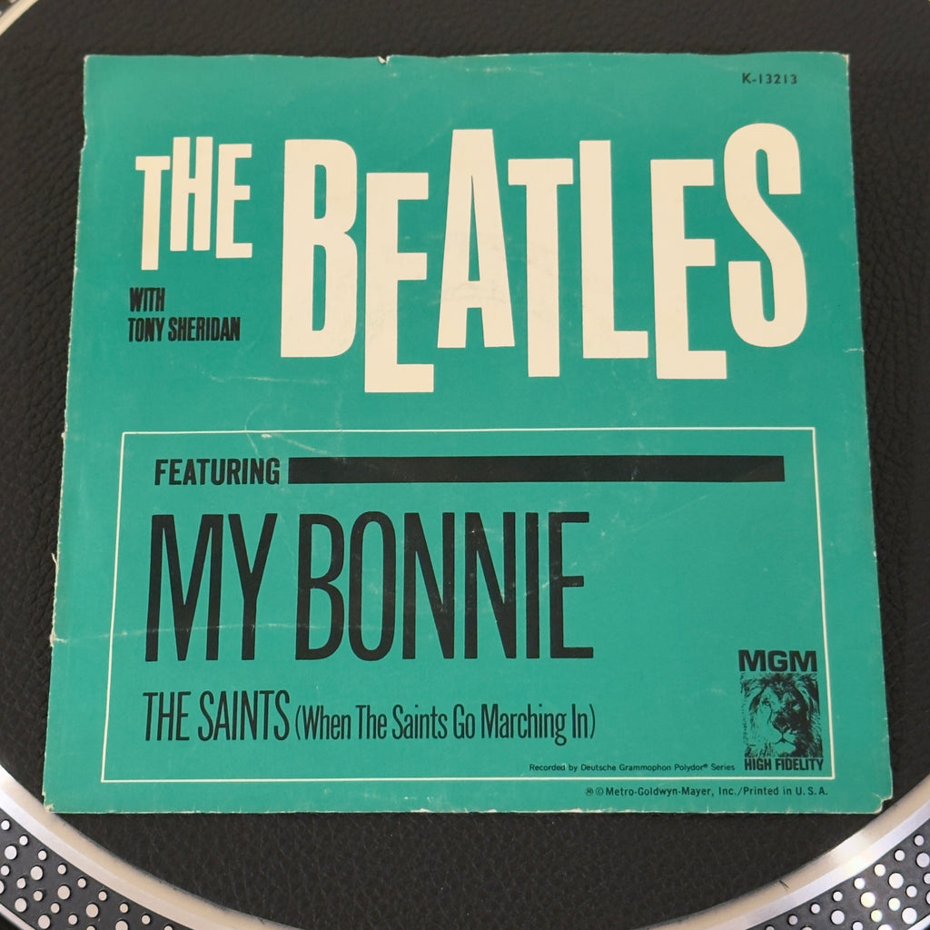 7" vinyl record by Beatles, The W/ Tony Sheridan featuring "My Bonnie (My Bonnie Lies Over The Ocean)/The Saints (When The Saints Go Marching In)", released on MGM Records (K-13213), in VG (Very Good) condition, classic analog collectable for turntable playback. MGM reissued these historic 1961 recordings in 1964 just as the band took America by storm.  Pic Sleeve.
