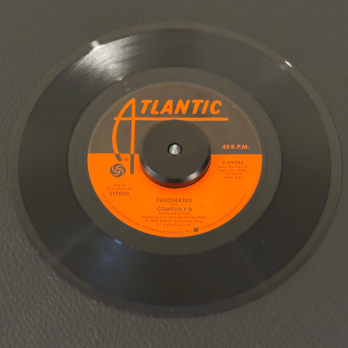 7" vinyl record by Company B featuring "Fascinated (Vocal)/(Dub)", released on Atlantic (7-89294), in NM (Near Mint) condition, classic analog collectable for turntable playback. Monumental pillar of late-1980s club culture and golden era of Latin Freestyle and Hi-NRG dance music. Original Atlantic sleeve.