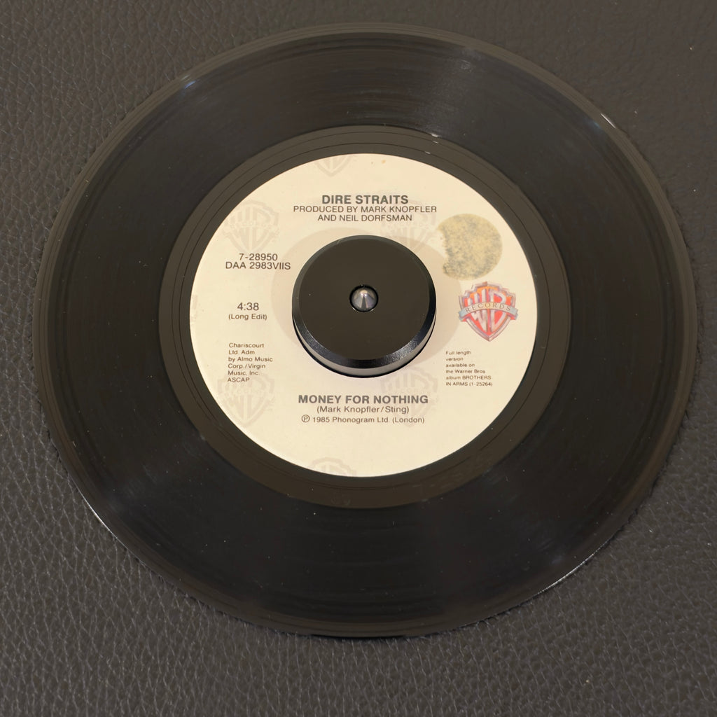 7" vinyl record by Dire Straits featuring "Money For Nothing (Long Edit)/Love Over Gold (Live)", released on Warner Bros. Records (7-28950), in VG+ (Very Good Plus) condition, classic analog collectable for turntable playback. "I want my MTV!" Co-written by Mark Knopfler and Sting—who provides the legendary, soaring falsetto background vocals—this single won the 1986 Grammy Award and features one of the most iconic, punchy guitar riffs in classic rock history. sought-after 4:38 "Long Edit" of the track.