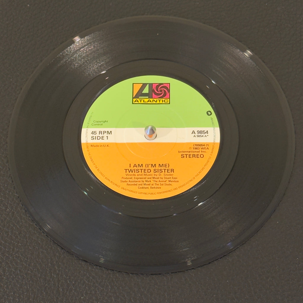 7" vinyl record by Twisted Sister featuring "I Am (I'm Me)/Sin After Sin", released on Atlantic (A 9854), in VG+ (Very Good Plus) condition, classic analog collectable for turntable playback. UK Pressing. Pic Sleeve Included.