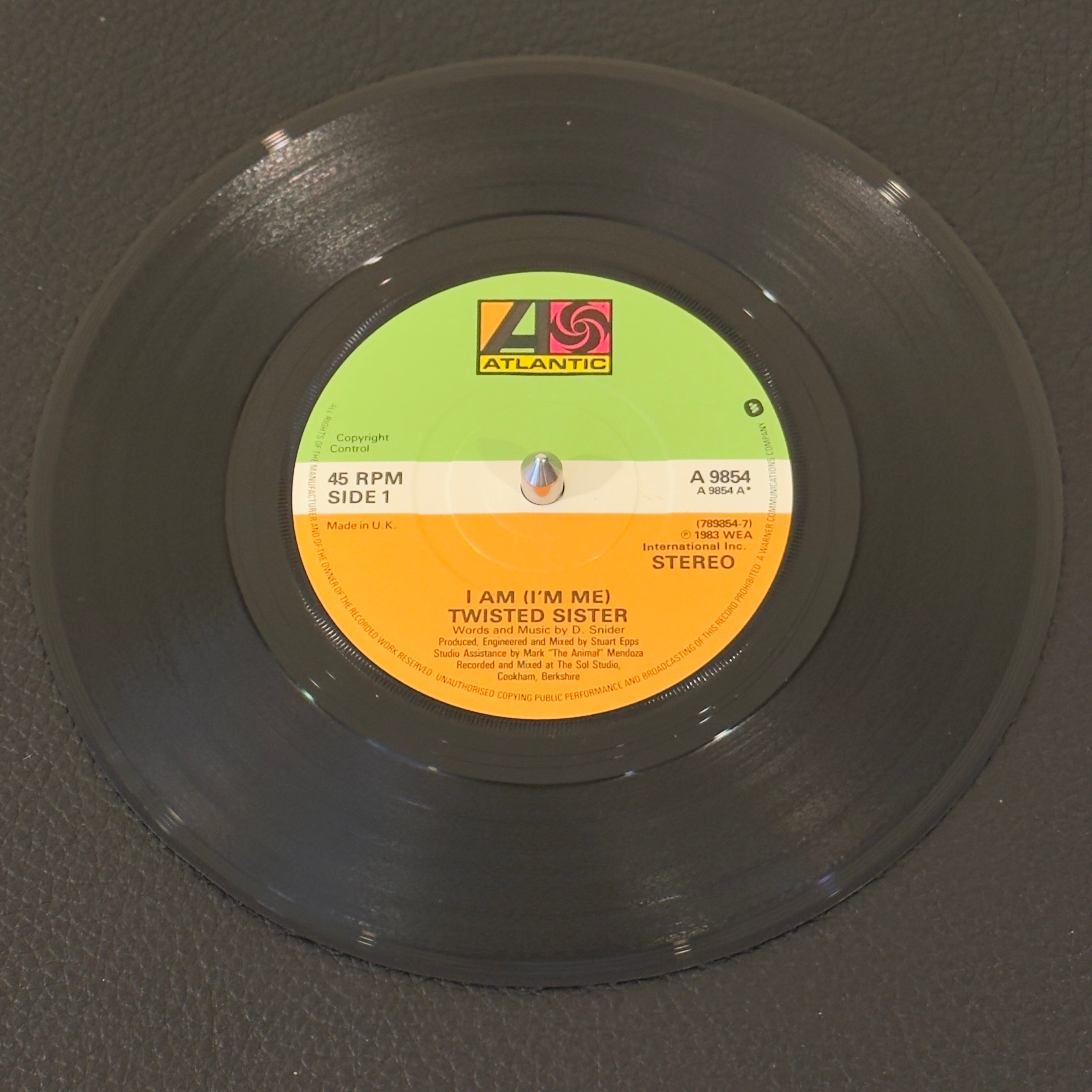 7" vinyl record by Twisted Sister featuring "I Am (I'm Me)/Sin After Sin", released on Atlantic (A 9854), in VG+ (Very Good Plus) condition, classic analog collectable for turntable playback. UK Pressing. Pic Sleeve Included.
