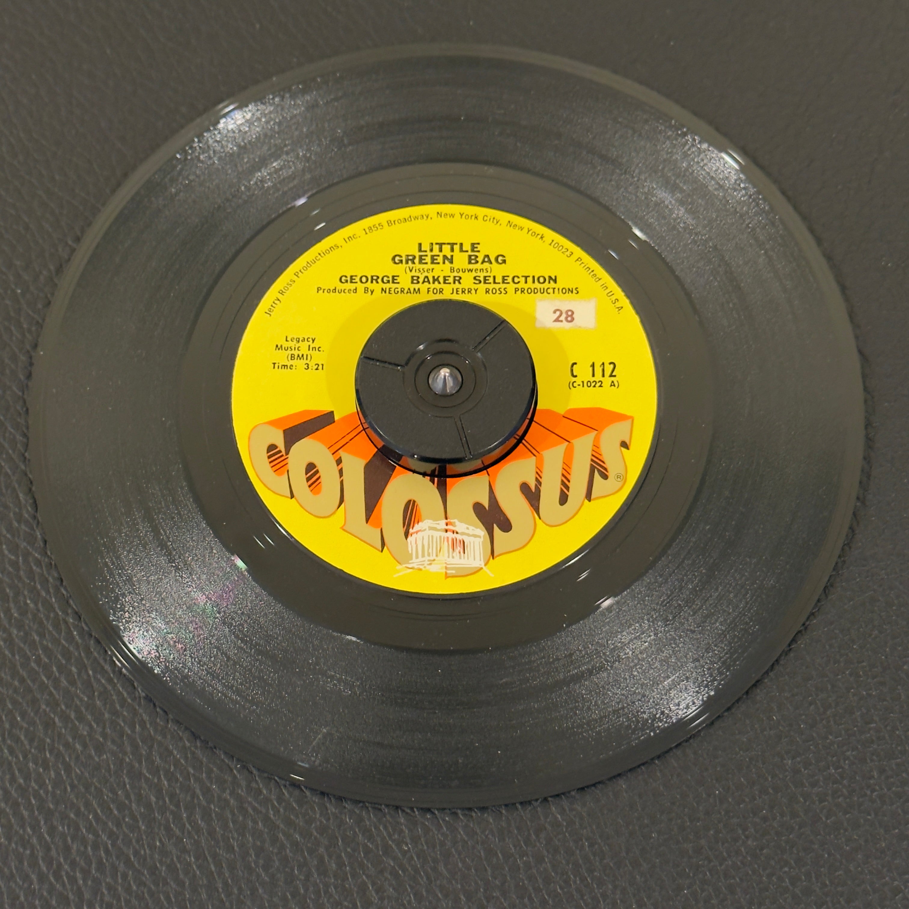 7" vinyl record by George Baker Selection featuring "Little Green Bag/Pretty Little Dreamer", released on Colossus (C 112), in NM (Near Mint) condition, classic analog collectable for turntable playback. Includes original Colossus sleeve.  Small sticker with #28 on both sides of label.