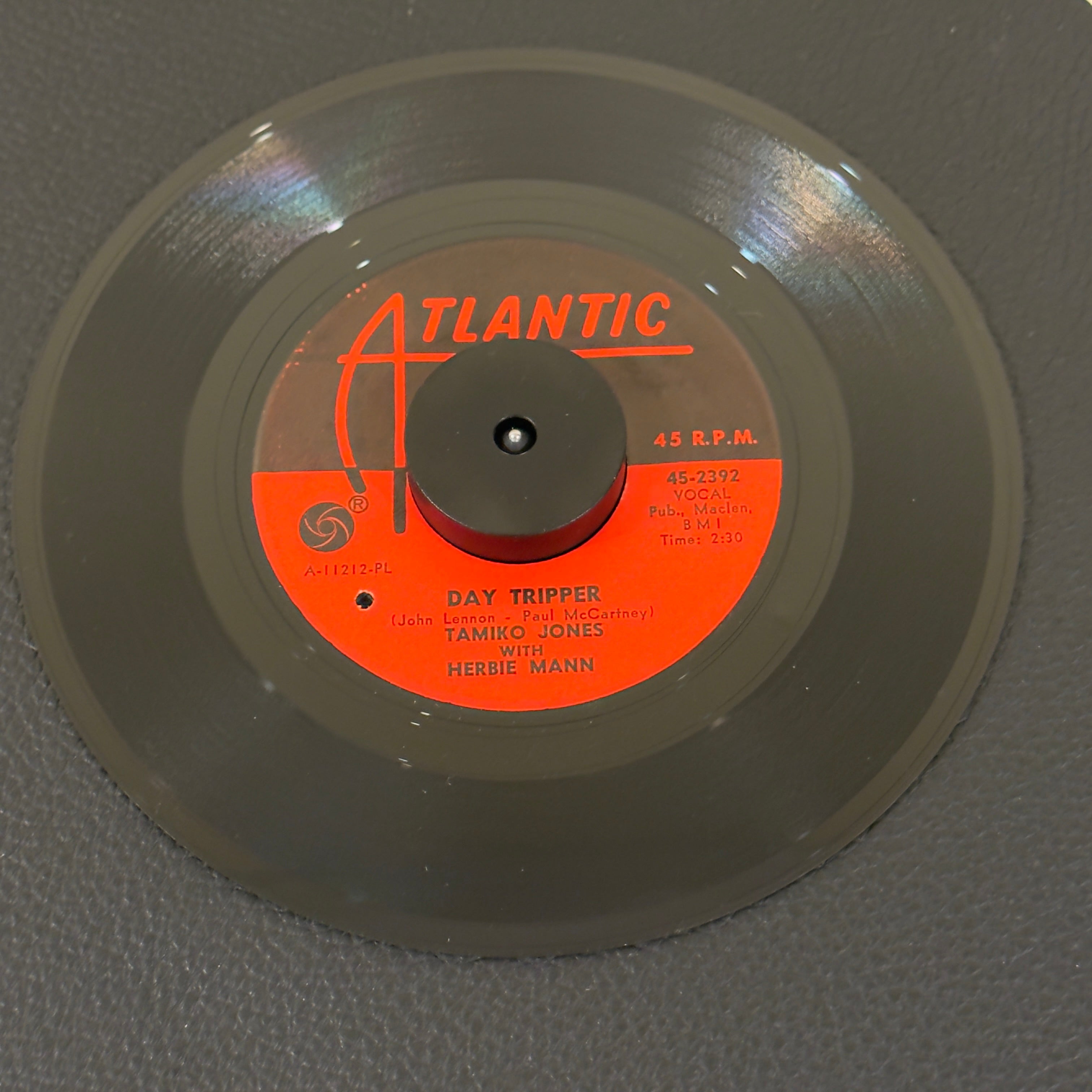 7" vinyl record by Tamiko Jones w/ Herbie Mann featuring "Day Tripper/A Good Thing (Is Hard To Come By)", released on Atlantic (45-2392), in VG+ (Very Good Plus) condition, classic analog collectable for turntable playback. Original Atlantic sleeve included. Punch hole in label. Side A composed by John Lennon & Paul McCartney.