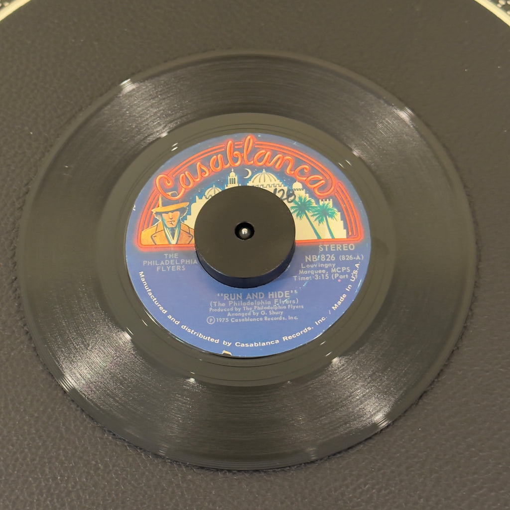 7" vinyl record by Philadelphia Flyers, The featuring "Run and Hide Part 1/Run and Hide (Complete Version)", released on Casablanca (NB 826), in VG+ (Very Good Plus) condition, classic analog collectable for turntable playback. Includes original Casablanca sleeve.  Slight writing on both sides of labels.