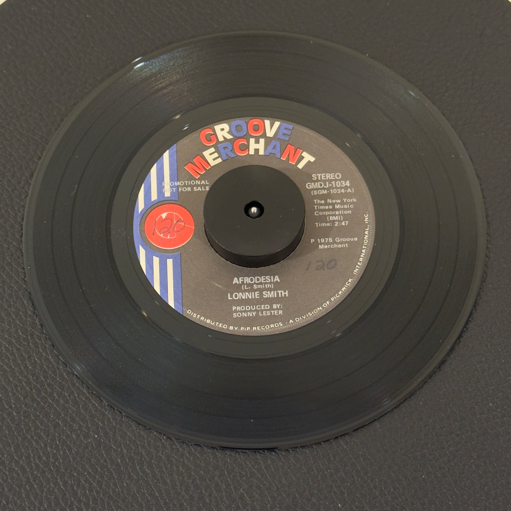 7" vinyl record by Lonnie Smith featuring "Afrodesia (Stereo)/Afrodesia (Mono)", released on Groove Merchant (GMDJ 1034), in VG+ (Very Good Plus) condition, classic analog collectable for turntable playback. Promotional Copy. Slight writing on both sides of label.