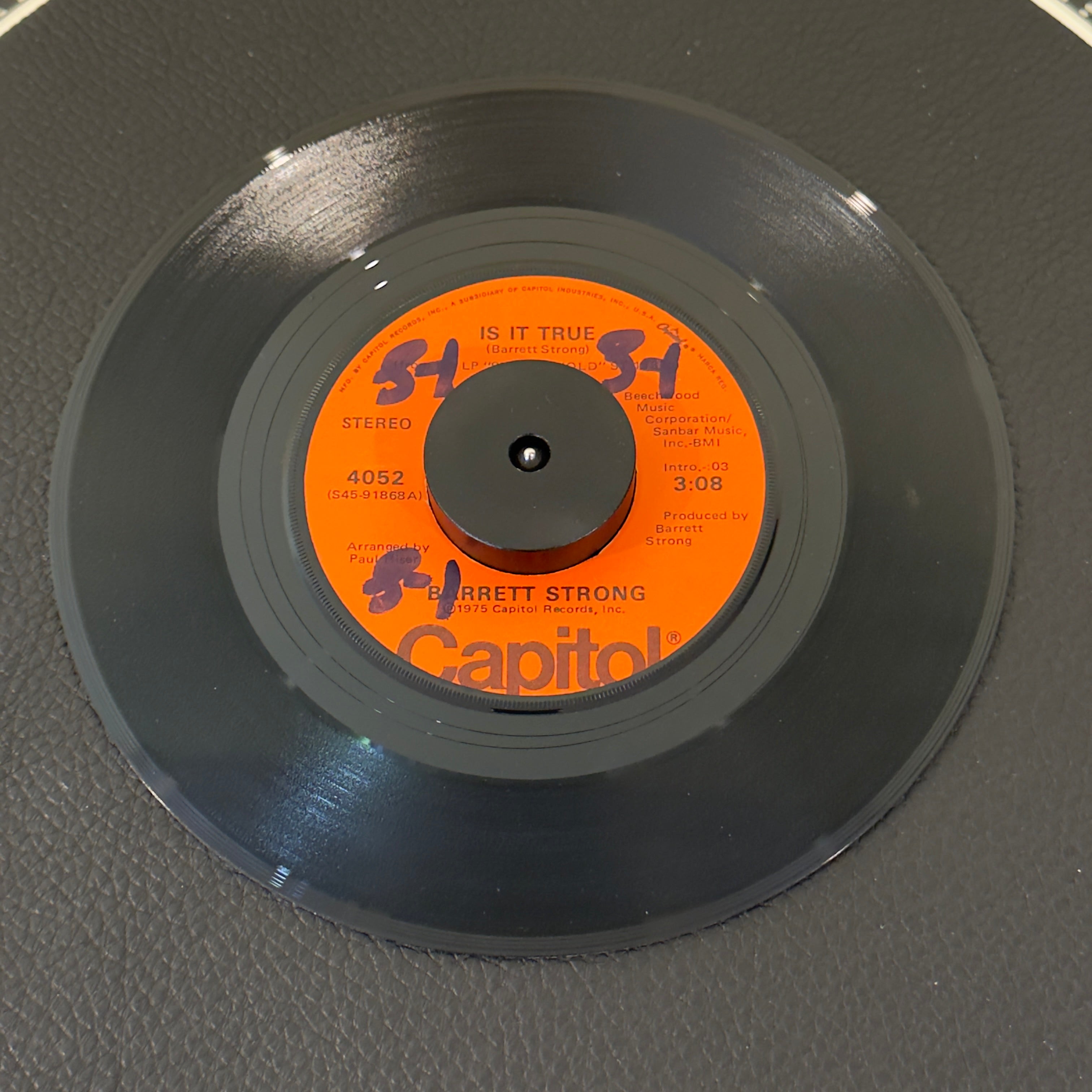 7" vinyl record by Barrett Strong featuring "Is It True/Anywhere", released on Capitol Records (4052), in VG+ (Very Good Plus) condition, classic analog collectable for turntable playback. Rare orange label!  Includes original Capitol sleeve.  Writing on one side of label.