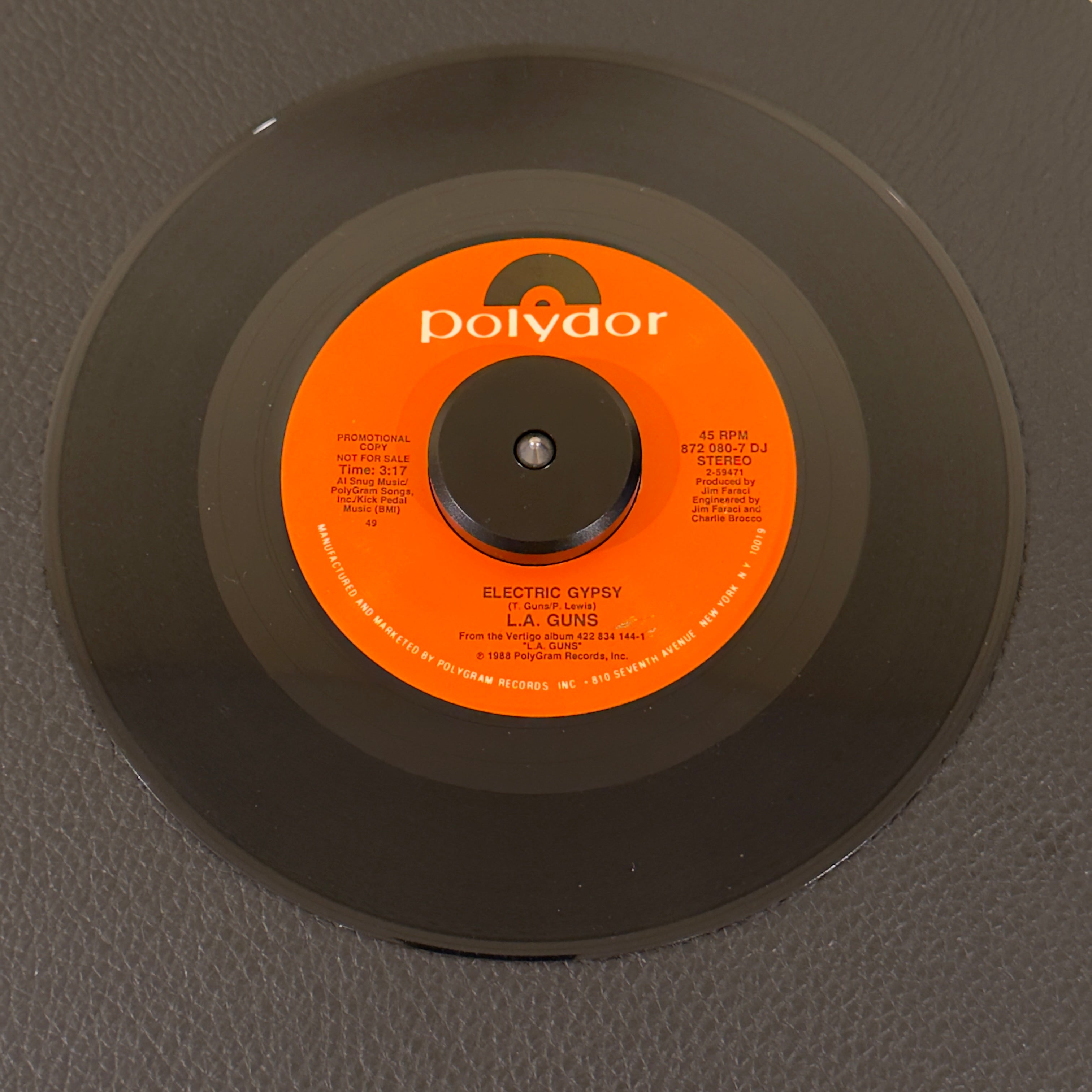 7" vinyl record by L.A. Guns featuring "Electric Gypsy", released on Polydor (872-080-7 DJ), in NM (Near Mint) condition, classic analog collectable for turntable playback. Rare 1980's Hair Metal promo in original Polydor sleeve!!