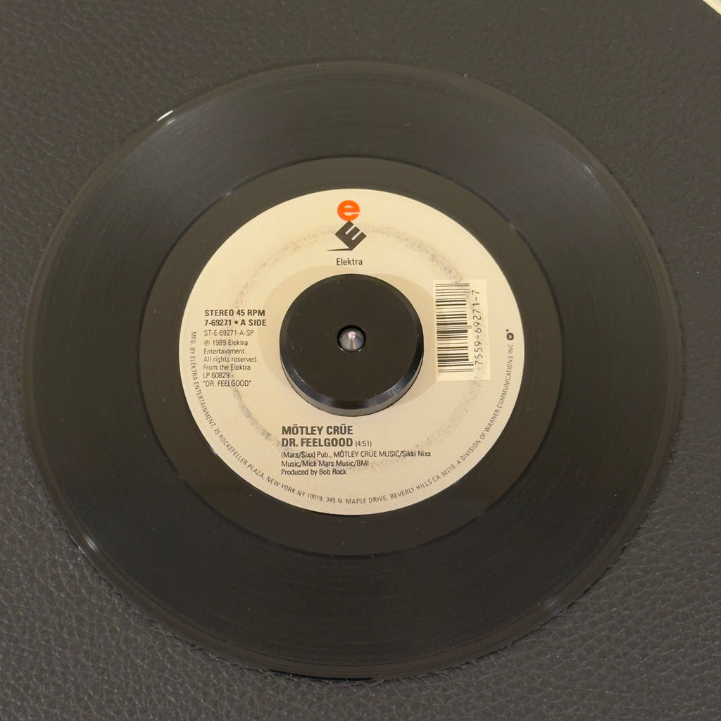7" vinyl record by Motley Crüe featuring "Dr. Feelgood/Sticky Sweet", released on Elektra (7-69271), in VG+ (Very Good Plus) condition, classic analog collectable for turntable playback. Ring on both sides of the label.  Motley Crüe's highest charting single at No.6! Does not include pic sleeve.