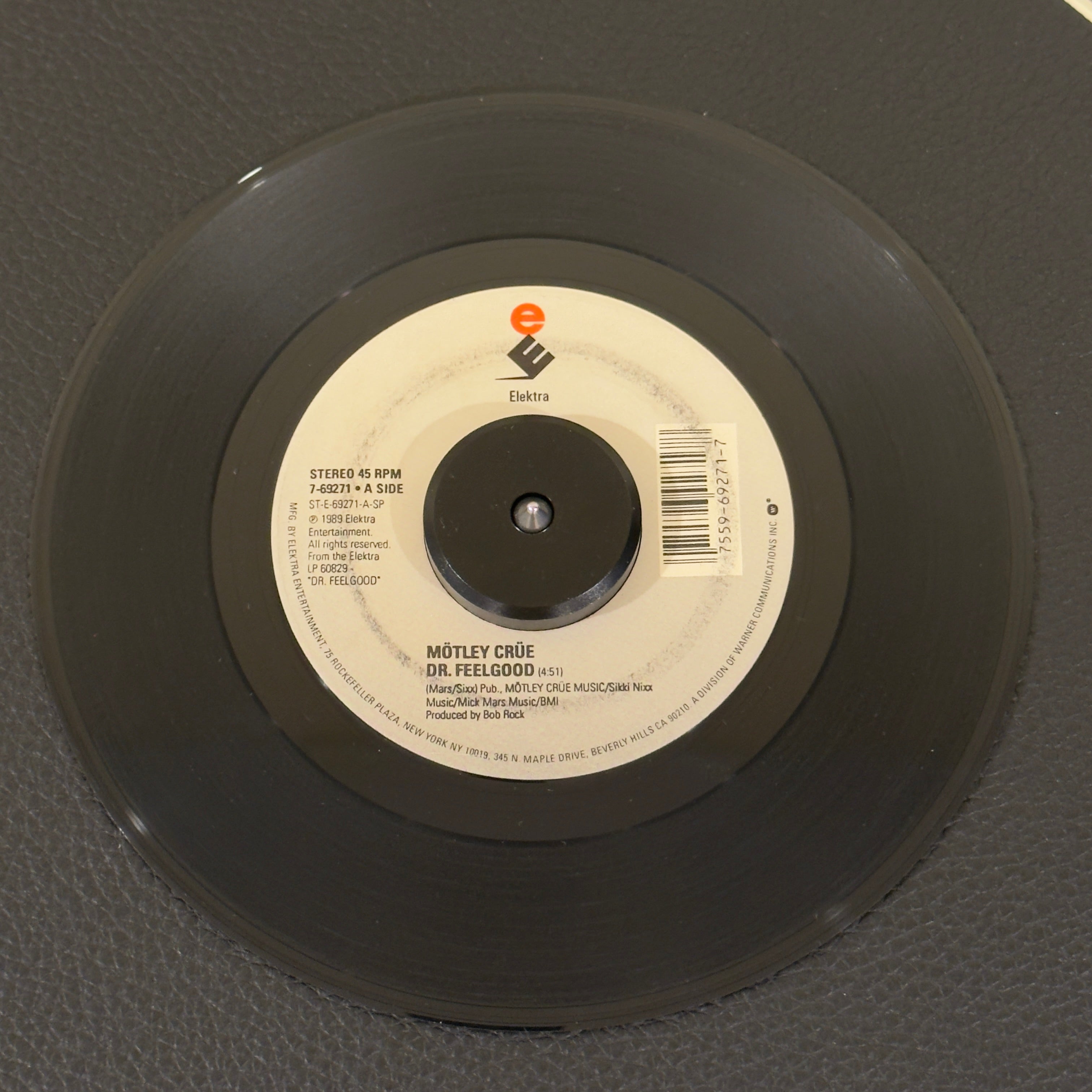 7" vinyl record by Motley Crüe featuring "Dr. Feelgood/Sticky Sweet", released on Elektra (7-69271), in VG+ (Very Good Plus) condition, classic analog collectable for turntable playback. Ring on both sides of the label.  Motley Crüe's highest charting single at No.6! Does not include pic sleeve.